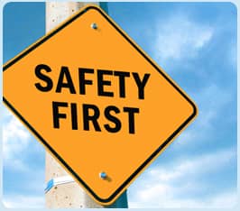 Yellow road sign with the words 'Safety First' against a blue sky.